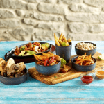 Cast Iron Sizzle Platter and Wooden Trivet with food and drinks