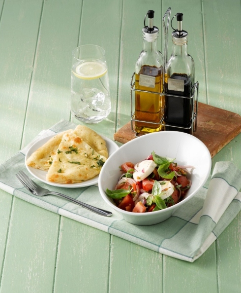 Oil and vinegar chrome stand with garlic bread and salad