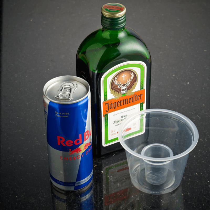 Empty Bomb Shot Glass next to Red Bull and Jaegermeister