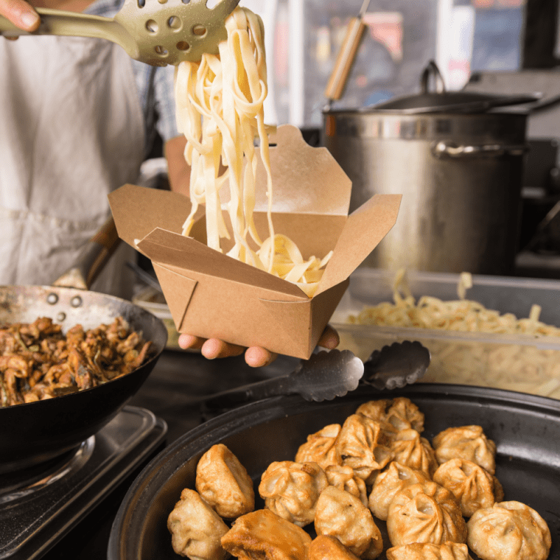 Noodles being served into a Kraft Deli Box