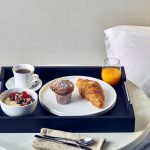Black Butler Tray with continental breakfast, served in a hotel bedroom.