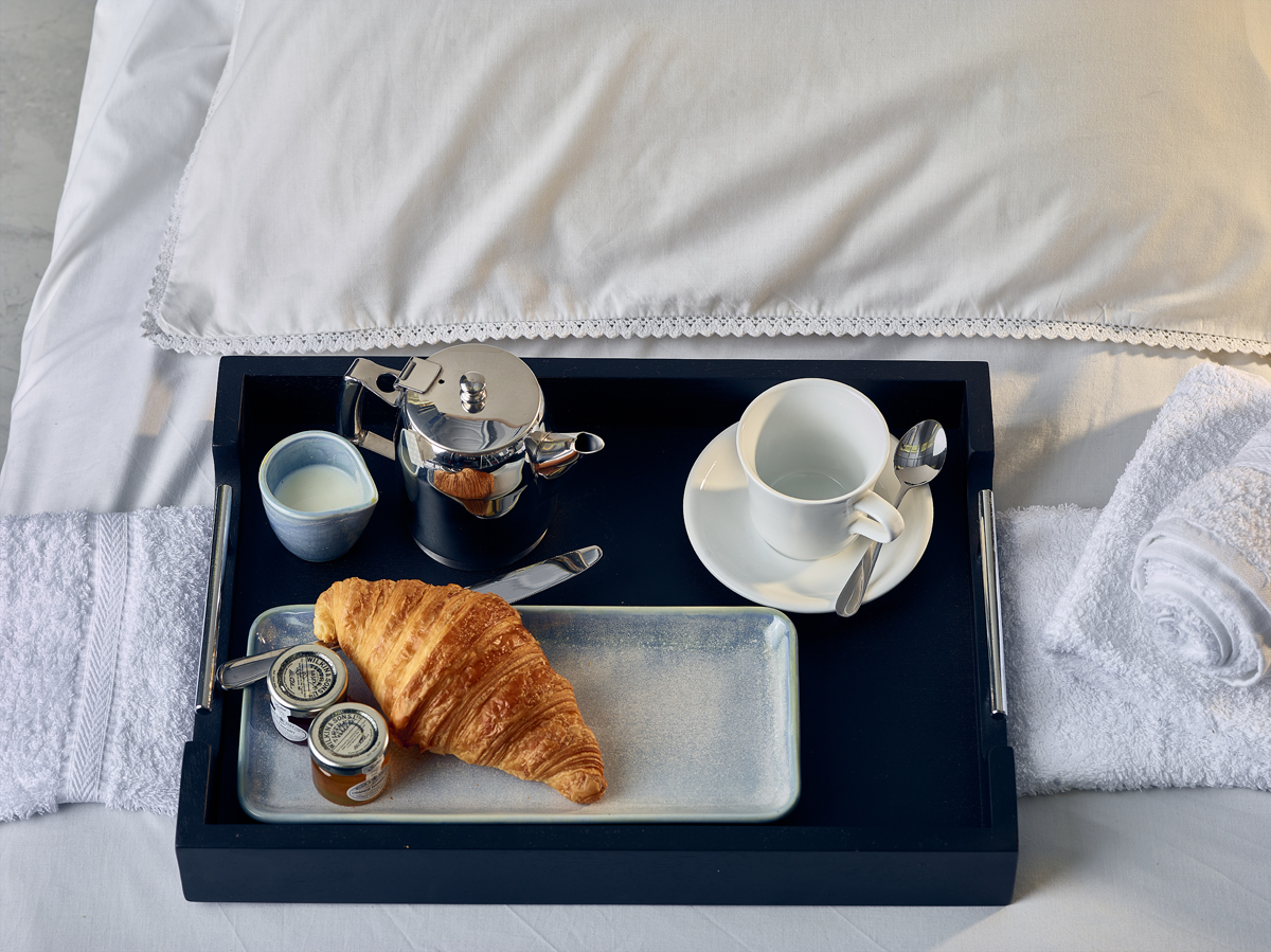 Black Butler Tray with tea and croissant.