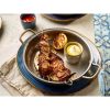 Vintage Steel Round Dish on a blue plate and filled with food