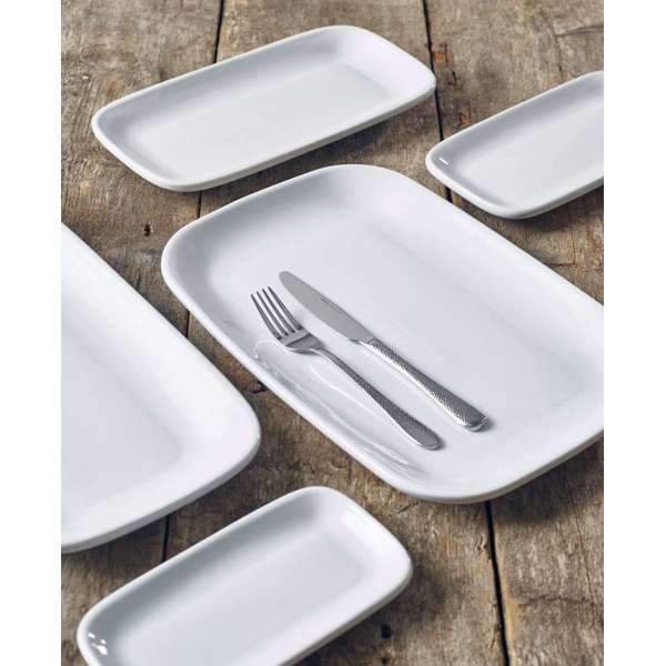 Collection of white rounded rectangular plates with cutlery