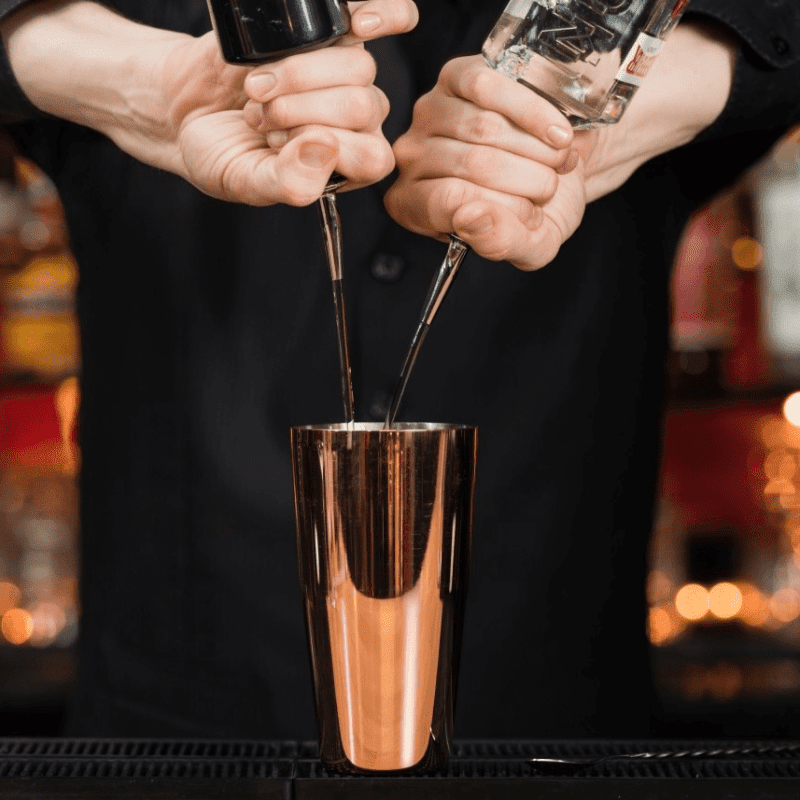 Pouring spirits into a copper plated boston shaker lifestyle