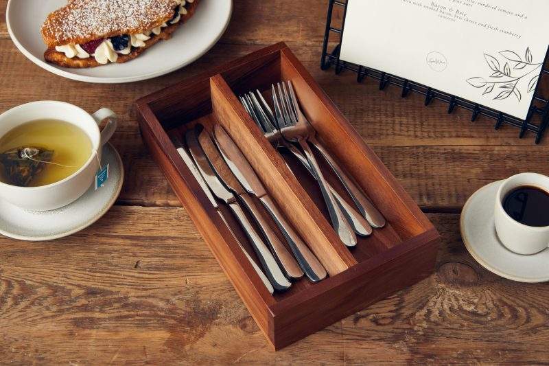 Lifestyle image of 2 compartment acacia wood cutlery tray complete with cutlery