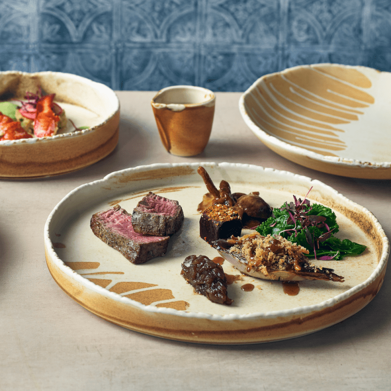 Meat dish served on a 28cm Roko Sand Presentation Plate