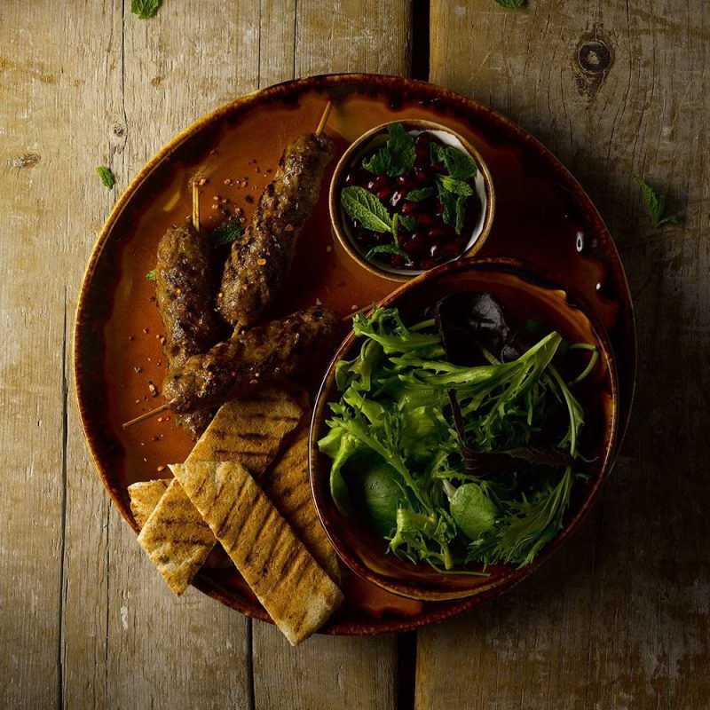 Middle Eastern food served on a Harvest Brown Coupe Plate