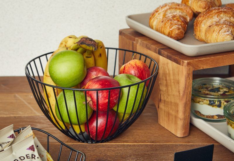 Fruit displayed in a round black wire basket